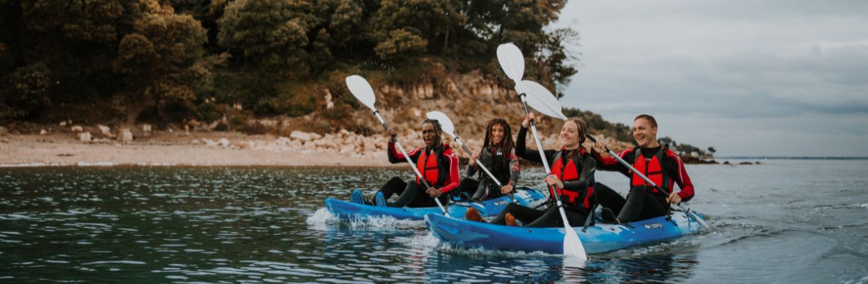 Group of people in canoes on the water around the Isle of Wight