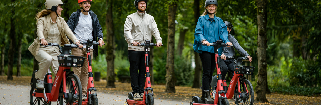 Group of people on Voi electric scooters and electric bikes
